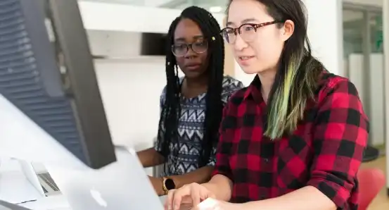 Two women looking at a computer screen together