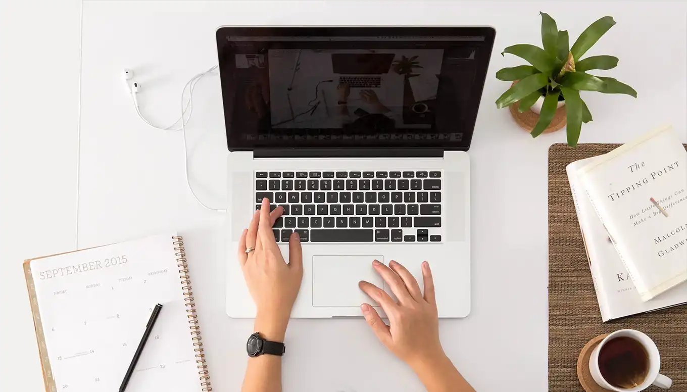 Overhead shot of someone working on a Macbook at a desk